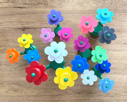 Colorful flower-shaped plastic bouquets on a wooden surface