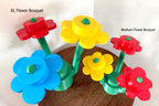 Colorful plastic flower bouquets on a wooden surface with labels for size.