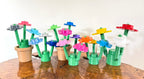 Colorful 3D flower-shaped bouquets on a wooden surface with a white background