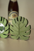 Green leaf-shaped bottle opener with a beer bottle in the background