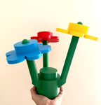 Colorful plastic flower bouquet set held by a hand against a beige background