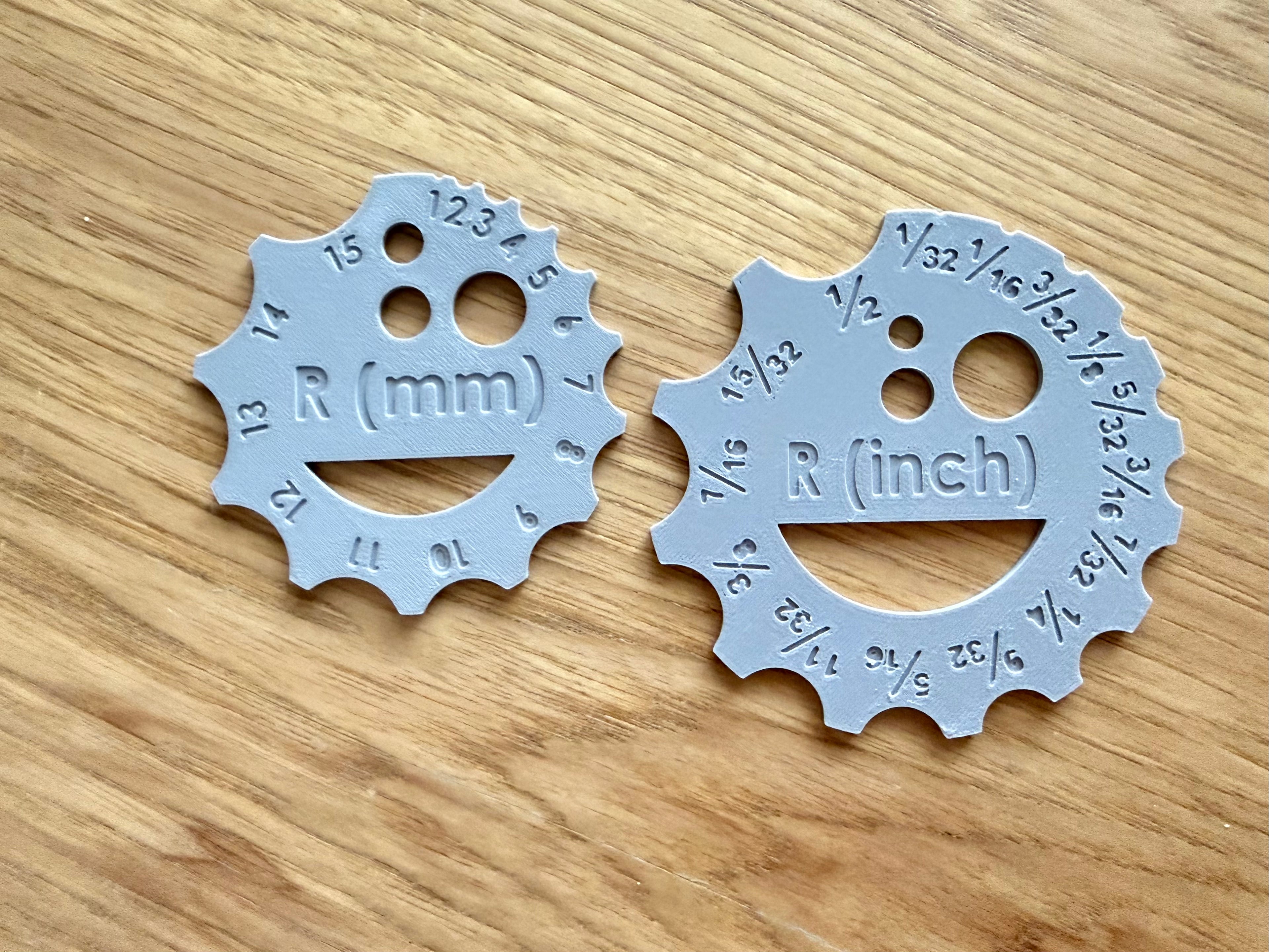 Two plastic circular measuring tools with measurements on a wooden surface