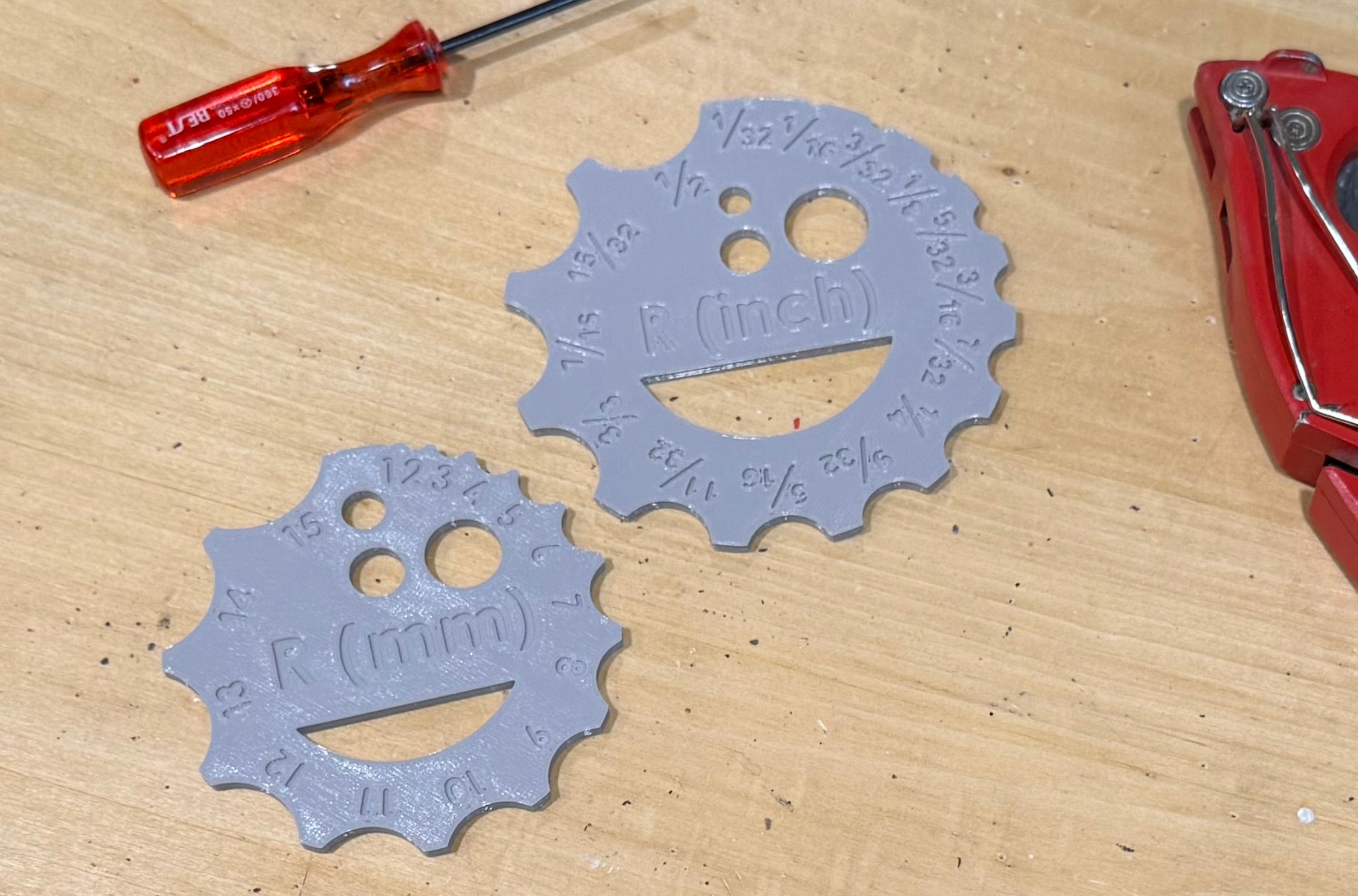 Two plastic circular measuring tools with measurements on a wooden surface