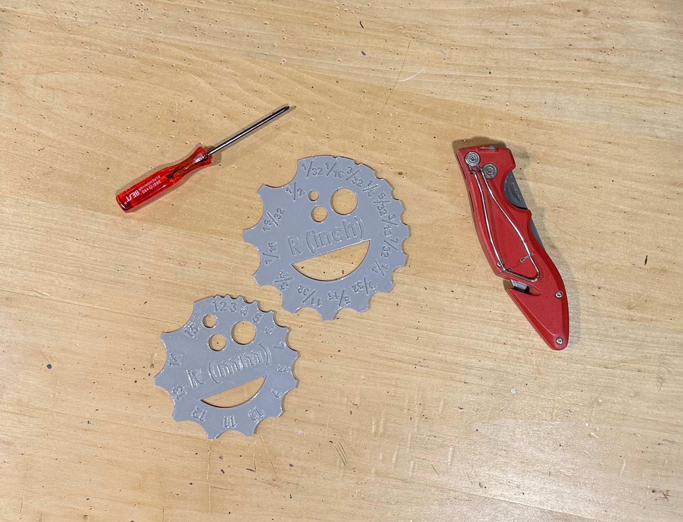 Two plastic circular measuring tools with measurements on a wooden surface