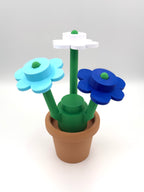 Plastic flower pot with blue and green flowers on a white background