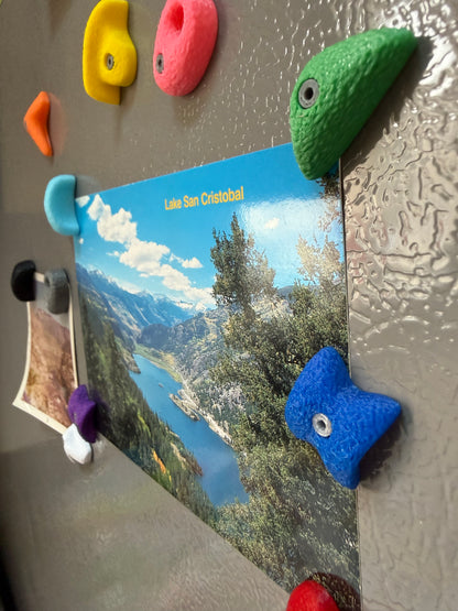 Colorful magnetic rock bouldering photo holders on a refrigerator with scenic photos attached.