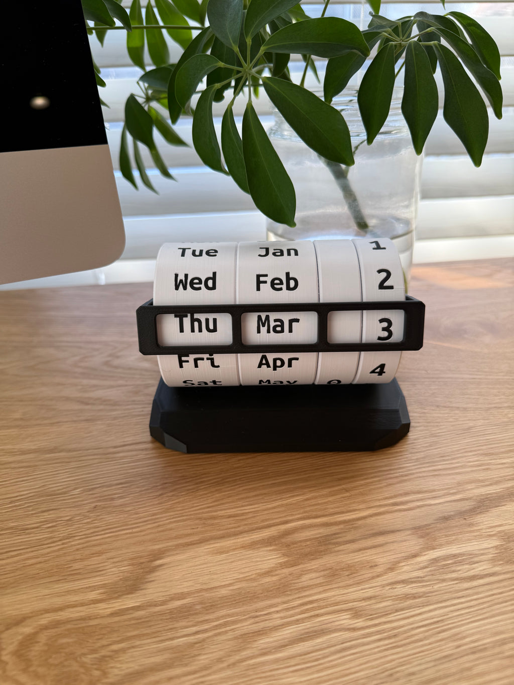 Weekly pill organizer on a wooden surface with a plant in the background