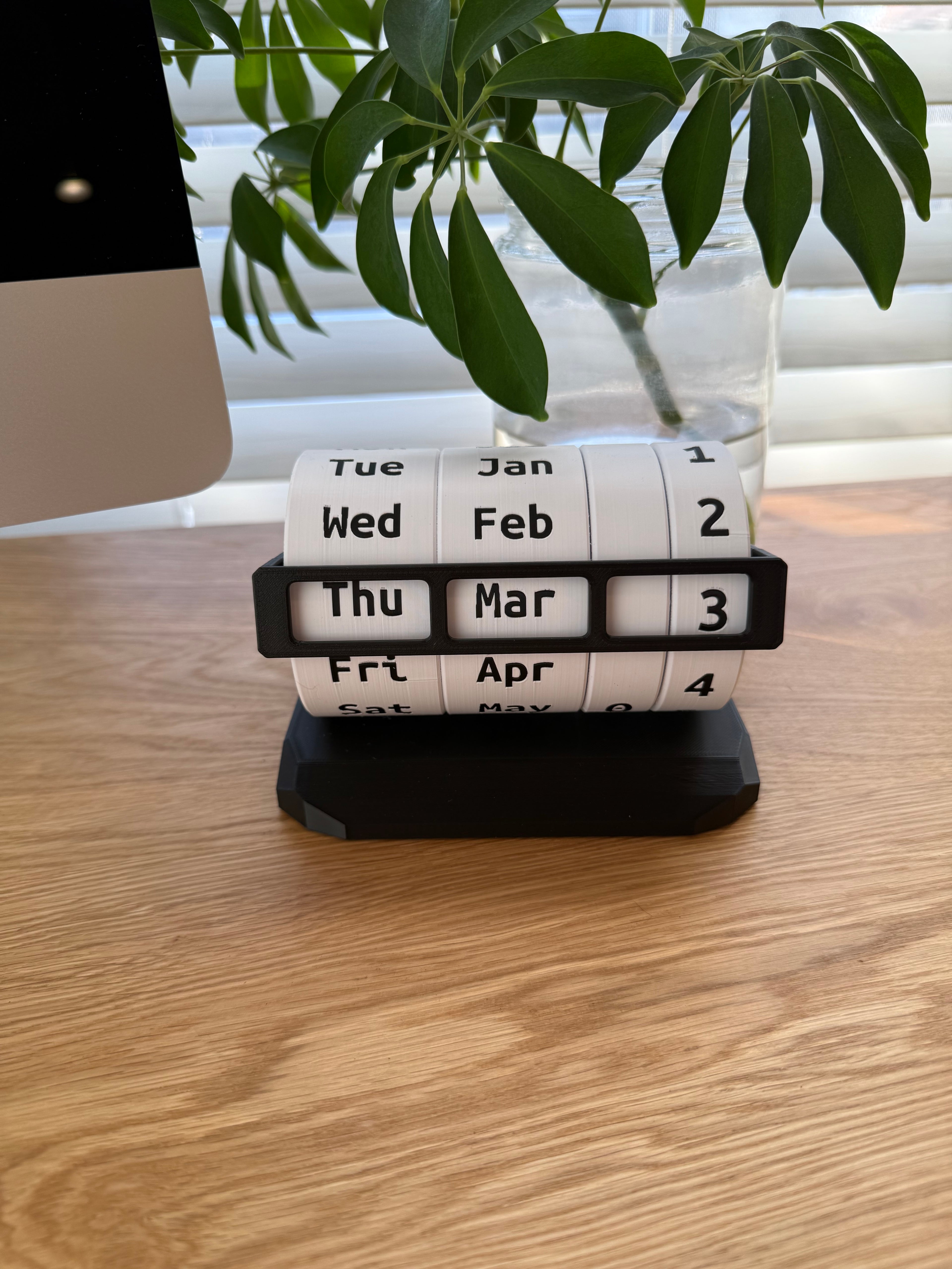 Weekly pill organizer on a wooden surface with a plant in the background