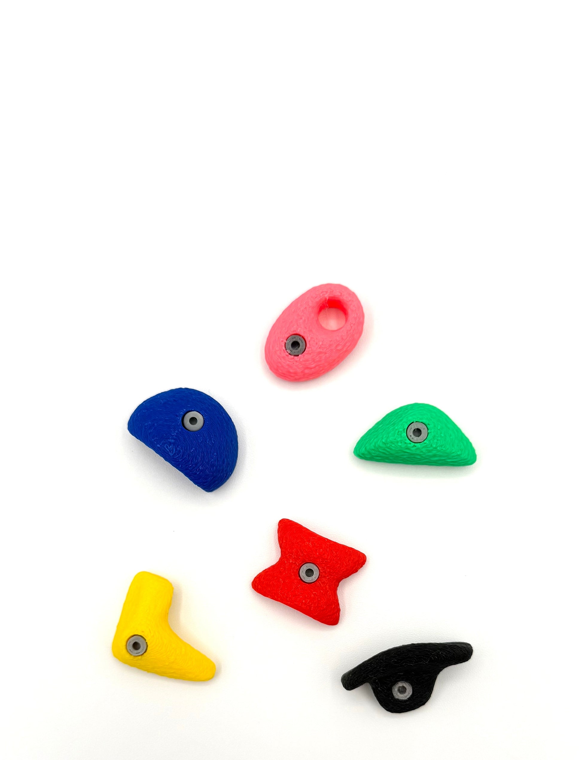 Set of colorful plastic rock bouldering magnets on a white background