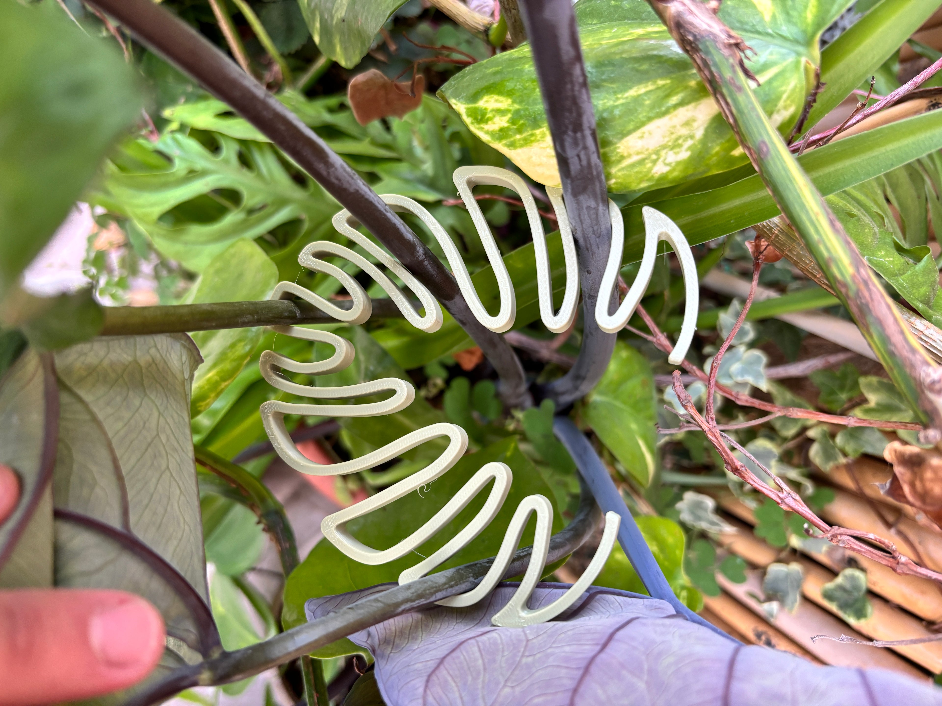 Close-up of a plant with a decorative plastic sculpture shaped like a leaf.