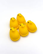 Five yellow plastic ducks on a white background