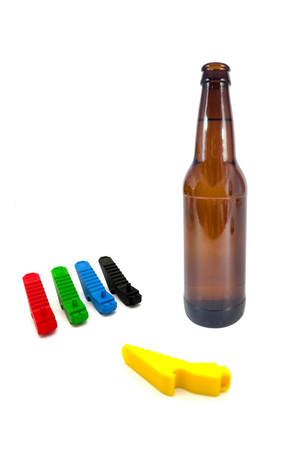 Five colorful plastic LEGO bottle openers on a white background with brown bottle